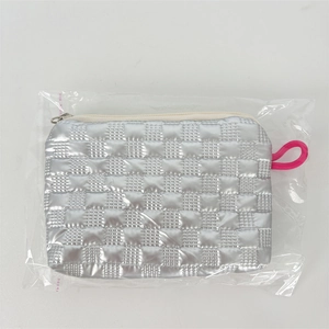 Macro detail of silver quilted PU pouch featuring metal zipper and pink braided strap