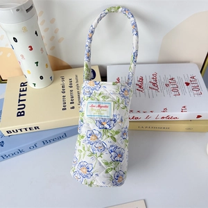 Close-up of quilted floral water bottle holder with soft cotton padding and handle