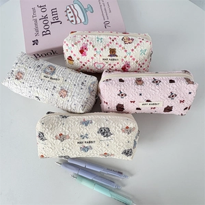 Détail de trousses matelassées avec étiquette MAY RABBIT et motifs de dessins animés