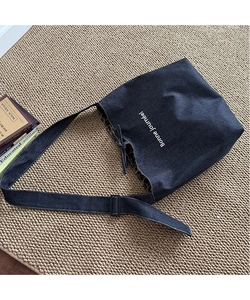 Detail of denim tote bag showing leopard print lining and adjustable shoulder strap