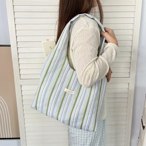 Close-up of rainbow striped canvas tote bag with green and blue vertical pattern