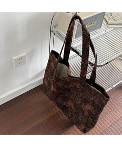 Detailed view of leopard print canvas tote bag hanging on a rack in a warm interior setting