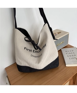 Detail of canvas tote bag featuring First Encounter print and drawstring closure
