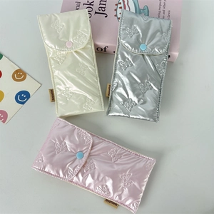 Quilted bow texture storage pouches in cream, silver, and pink with snap closure details
