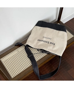 Detail of canvas tote bag showing two-tone denim stitching and drawstring closure