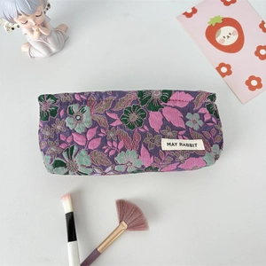 Detail of purple floral jacquard makeup bag with May Rabbit label and embroidery texture