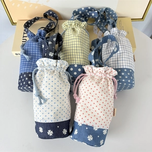 Dettaglio di borse termiche per borracce con chiusura a coulisse e vari motivi