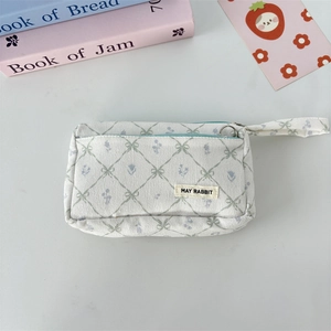 Detail view of double-layer corduroy pencil case with green grid and blue floral patterns