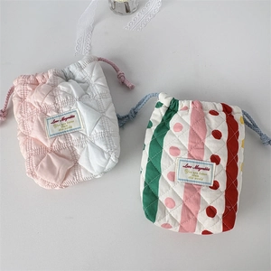 Detail of quilted drawstring camera bags featuring soft padded fabric and floral patterns