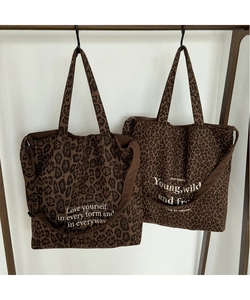 Detalle de bolso tote de pana con estampado de leopardo y letras blancas decorativas