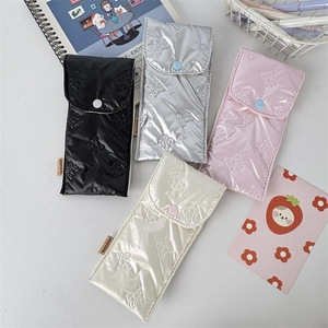 Detailed view of quilted bow storage bags in black, silver, pink, and white colors