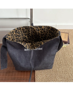 Detail of denim tote bag with leopard print lining and Bonne journée white text