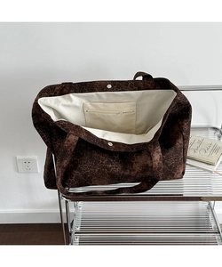 Detail view of large leopard print tote bag featuring zip inner pocket and magnetic closure