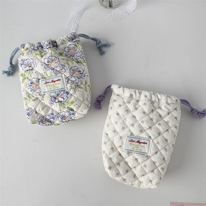 Detail view of quilted cotton drawstring bags with blue floral and purple polka dot patterns