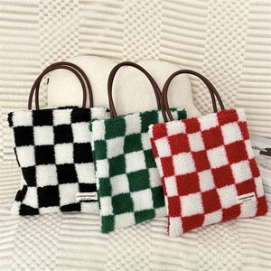 Vue détaillée de cabas à damier en peluche en tissus noir, vert et rouge doux