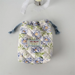 Detail of quilted cotton drawstring bag featuring fresh floral patterns and blue drawcord