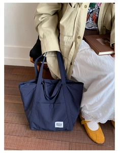 Detail of navy blue nylon tote bag with natural texture and Beyou Merci woven label