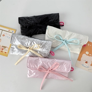 Detailed view of four colors quilted bow stationery bags with glossy finish and ribbon detail