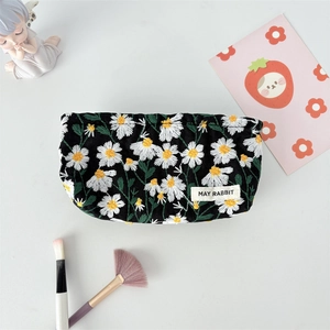 Detail of daisy embroidery on black jacquard cosmetic bag with May Rabbit woven label
