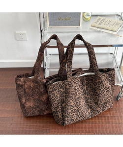 Close-up of two large canvas tote bags with different leopard print patterns on the floor