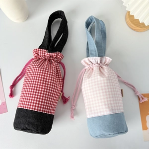 Detail of plaid patchwork water bottle bags with drawstring closure and carrying handle