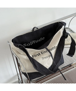 Detail of the high-capacity tote bag featuring chevron canvas and denim patchwork fabric