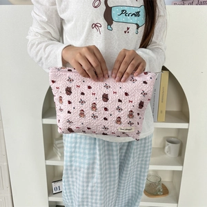 Détail du tissu matelassé rose avec motif d'ours et étiquette tissée de marque