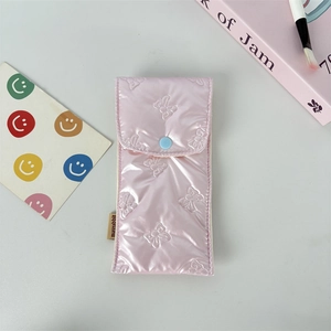 Detail of pink glossy bow-embossed pencil case with soft quilted texture and blue button