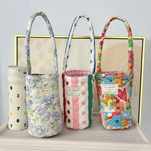 Detailed view of quilted cotton water bottle carriers with colorful patterns and handles