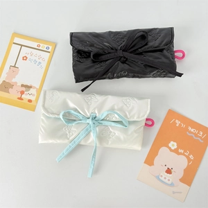 Quilted bow-patterned pencil pouch in glossy nylon with ribbon tie closure