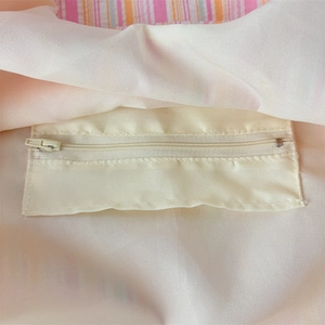 Internal view of striped tote bag showing a secure zippered pocket for storage