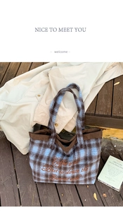 Close-up of the vintage blue plaid wool tote bag with orange embroidery and corduroy lining