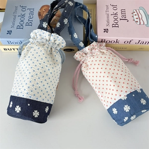 Dettaglio di borse porta borraccia con coulisse in denim patchwork a pois e fiori