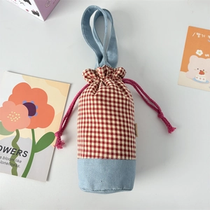 Detail of red checkered and denim patchwork water bottle bag with pink drawstring