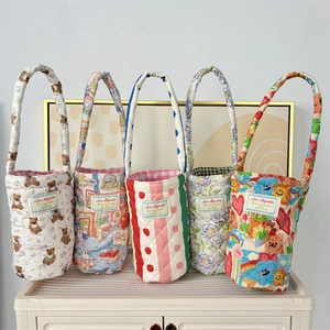 Detailed view of quilted cotton bottle sleeves with various cute floral and bear patterns