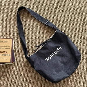 Large dark grey canvas tote bag with Solitude text and adjustable strap for commuting