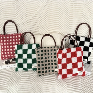 Gros plan de sacs cabas à damier en peluche avec poignées en cuir et étiquettes en tissu