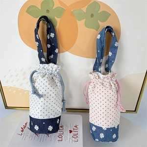 Dettaglio di borse con coulisse con patchwork denim e motivi a pois vivaci
