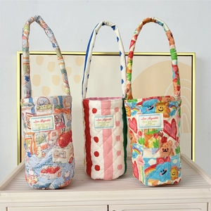 Detail of quilted floral cup holders with handles in blue town and pink stripe patterns