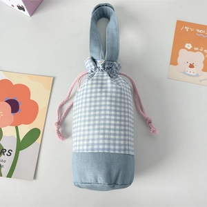 Detail of blue plaid water bottle carrier bag with pink drawstring and reinforced handle