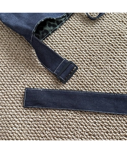 Detail of denim shoulder strap with matte black buckle and green leopard print lining