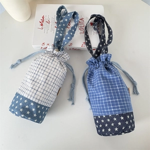 Dettaglio di borse per borracce in denim a quadri con coulisse e tracolla con stelle