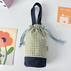 Detail of plaid water bottle bag with denim base and blue drawstring closure