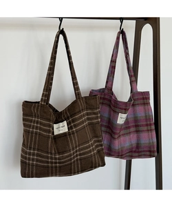 Detail of checkered woolen tote bags with handcrafted textile label and soft texture