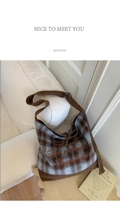 Detail of checkered canvas tote bag with corduroy strap and embroidered lettering