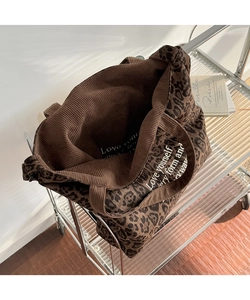 Detalle macro del bolso tote de pana con estampado de leopardo y texto blanco interno