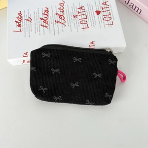 Détail de la pochette en velours côtelé noir avec nœuds gris et cordon rose