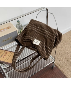 Close-up of retro plaid tote bag with handmade label on a vintage metal trolley