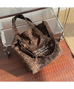 Detalle de bolso tote de lona con estampado de leopardo y texto blanco inspirador