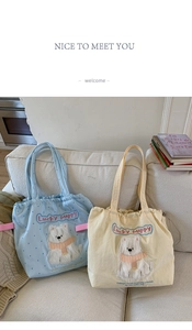 Detail of canvas tote bags with cute puppy embroidery and drawstring closure on a sofa